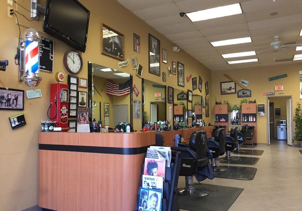 Inside Pro Barbers in Howell — yellow walls, classic chairs, the pole, and the vintage pump